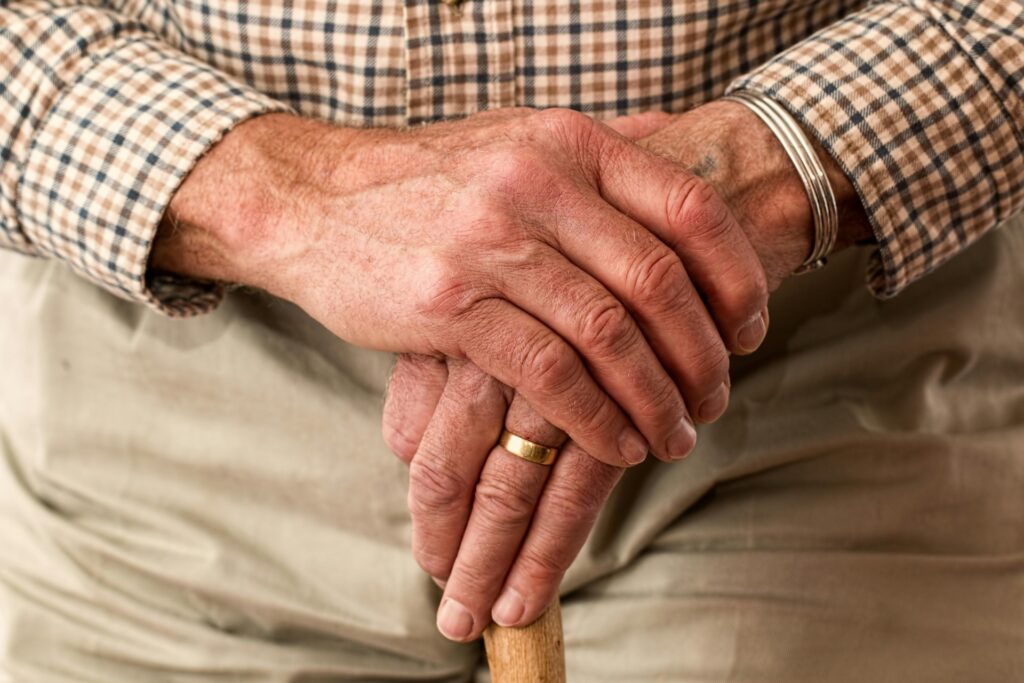 retired person holding walking stick