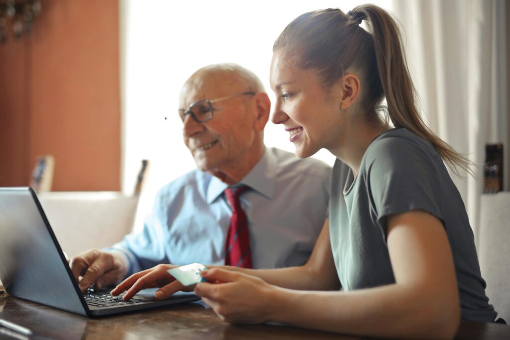 young woman being helped by senior finance man with investments