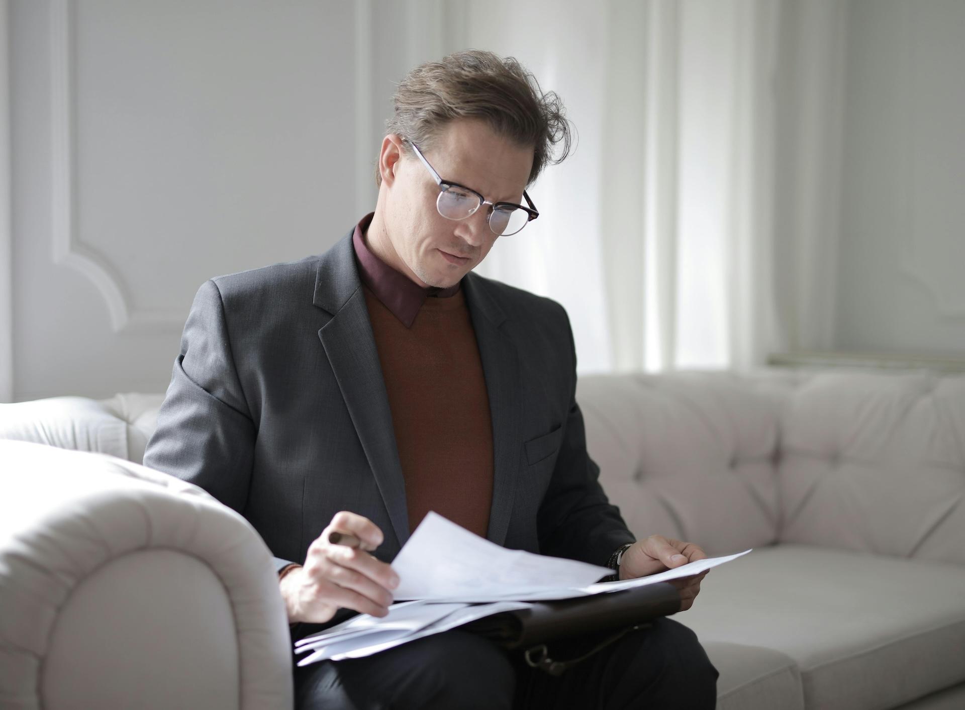 Man reading documents on couch